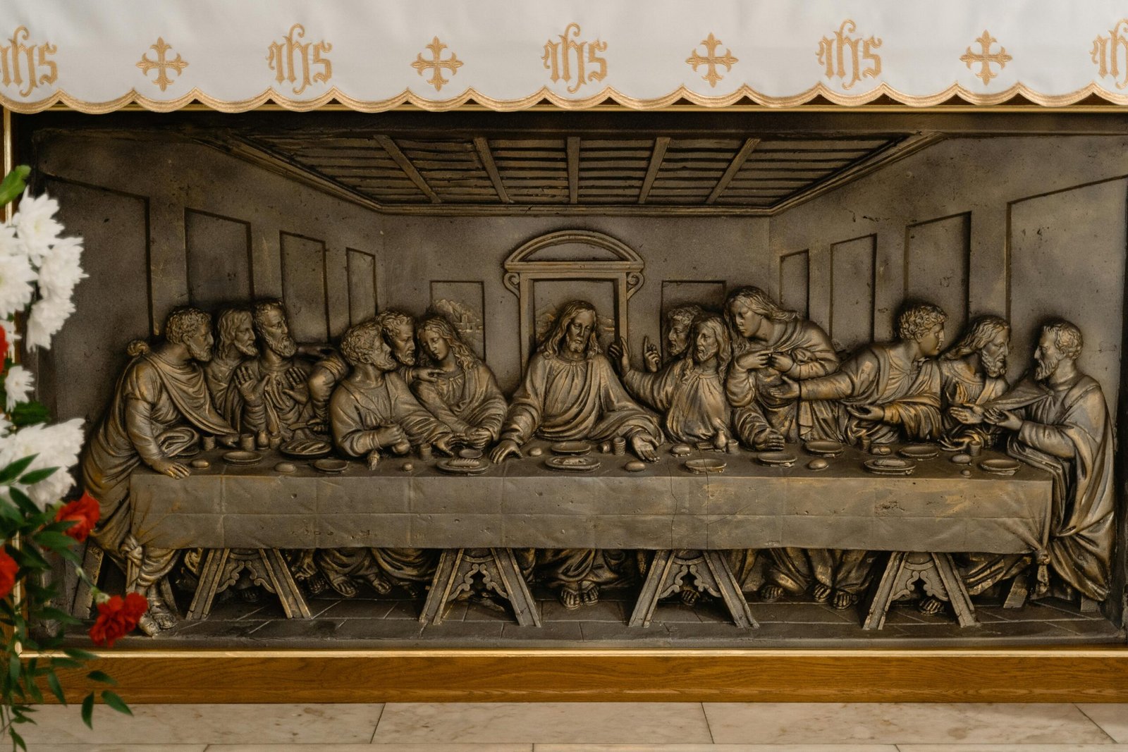 Close-up view of a detailed Last Supper metal relief sculpture, symbolizing a famed biblical scene.
